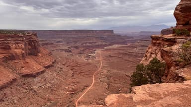 Un paysage désertique avec des formations rocheuses et un chemin sinueux.