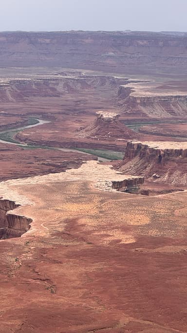 Un paysage désertique avec des formations rocheuses et une rivière.