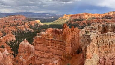 Un paysage de canyons rouges sous un ciel nuageux.