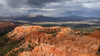 Un paysage de canyons rouges sous un ciel nuageux.