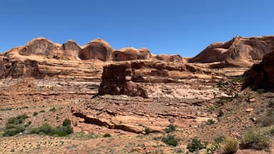 Un paysage désertique avec des formations rocheuses sous un ciel bleu.