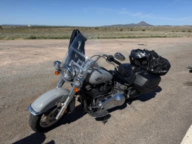 Une moto garée sur une route avec un paysage désertique en arrière-plan.