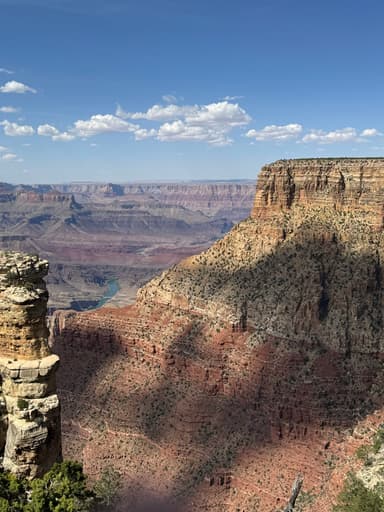 Un paysage du Grand Canyon avec des formations rocheuses et un ciel bleu.