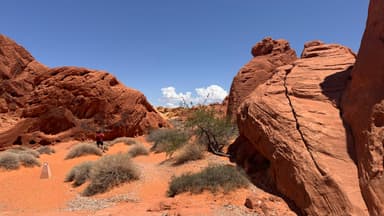 Un paysage désertique avec des rochers rouges et un ciel bleu.
