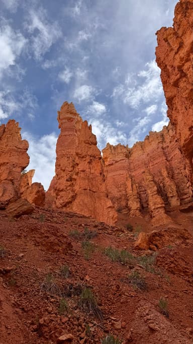 Un paysage de formations rocheuses rouges sous un ciel nuageux.