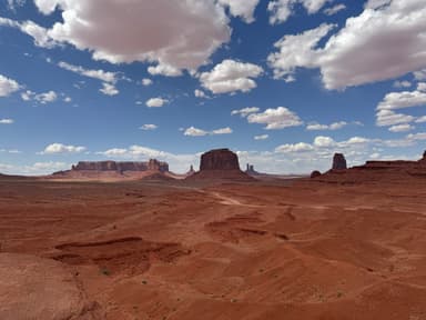 Un paysage désertique avec des formations rocheuses sous un ciel bleu.