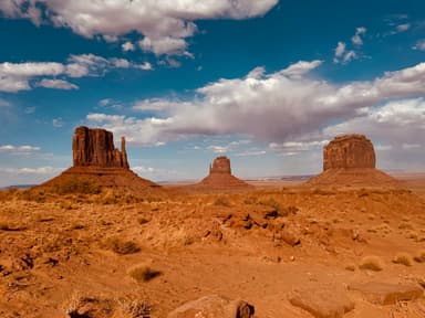 Un paysage désertique avec des formations rocheuses sous un ciel bleu.