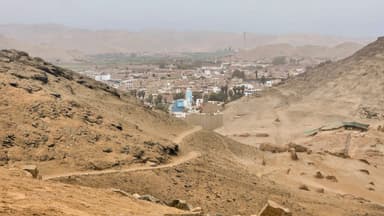 Une vue panoramique d'un paysage désertique avec un village au loin.