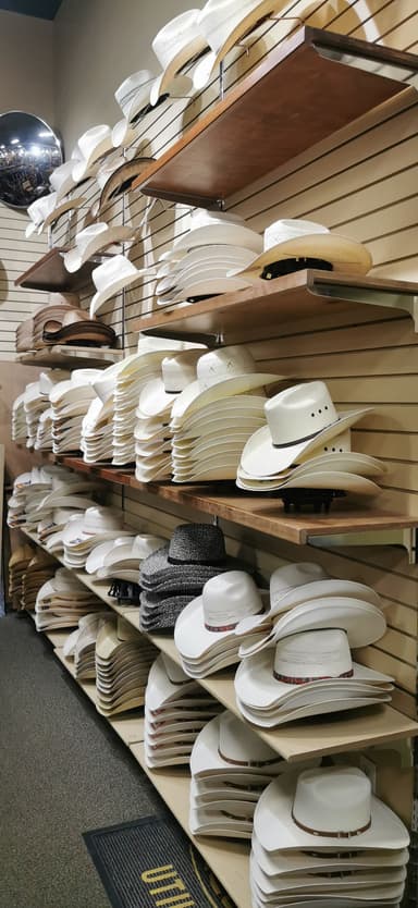 Des chapeaux blancs et noirs rangés sur des étagères.
