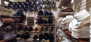Une boutique avec de nombreux chapeaux exposés sur des étagères.