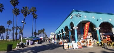 Une rue animée avec des palmiers et des bâtiments colorés à Los Angeles.
