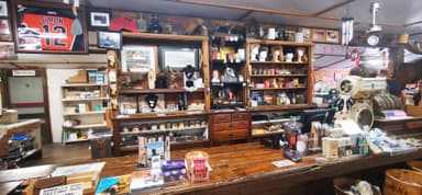 Une vue intérieure d'un magasin avec des étagères en bois et divers articles exposés.