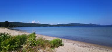 Une plage tranquille avec de l'eau claire et un ciel bleu.
