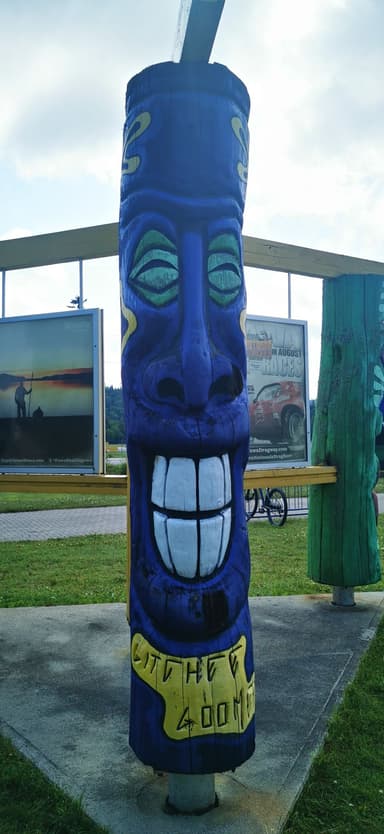 Un totem coloré avec un sourire, situé dans un parc.