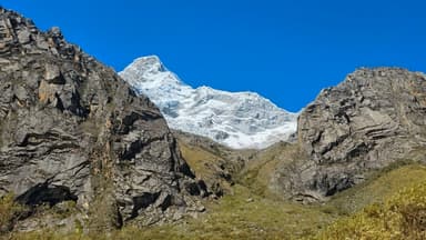 Une vue des montagnes avec un sommet enneigé sous un ciel bleu.