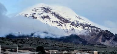 Un paysage montagneux avec des nuages et de la neige.