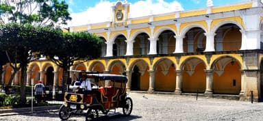 Un véhicule traditionnel devant un bâtiment historique à San Lucas Sacatepéquez.