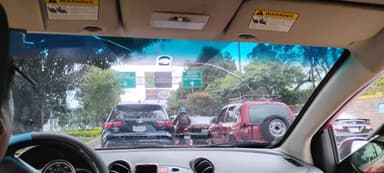 Une vue de la circulation à San Lucas Sacatepéquez, Guatemala, avec des panneaux de signalisation visibles.