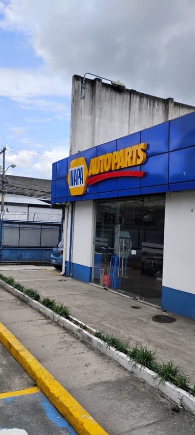 Un magasin de pièces automobiles sous un ciel nuageux.