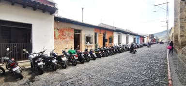 Une rue pavée avec des motos garées et des maisons colorées.