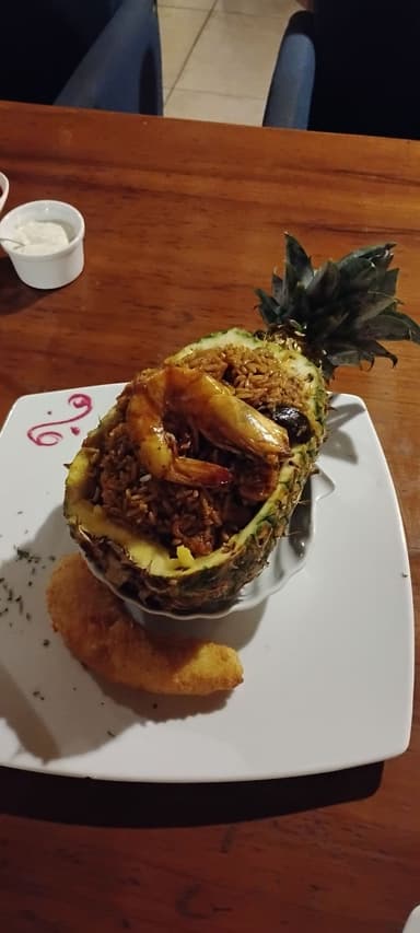 Un plat de riz aux crevettes servi dans une ananas.