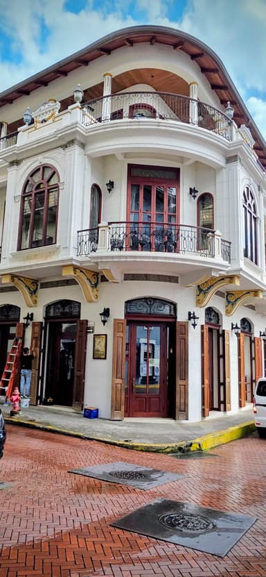 Un bâtiment colonial avec des balcons et des fenêtres à arcades sous un ciel bleu.