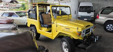 Un véhicule jaune garé dans un garage avec d'autres voitures.