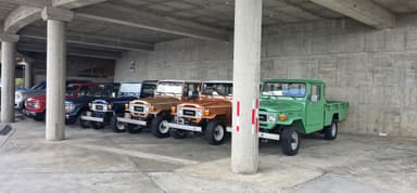 Des camions colorés garés sous un bâtiment en béton.