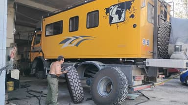 Un homme travaille sur un véhicule tout terrain dans un garage.