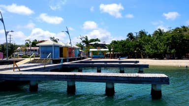 Un quai en bois avec des maisons colorées au bord de l'eau à Stann Creek.