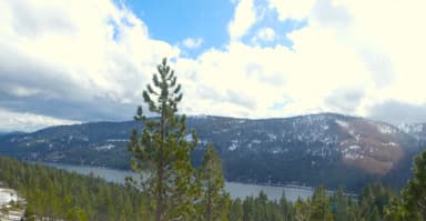 Un paysage de montagnes et d'un lac sous un ciel nuageux.