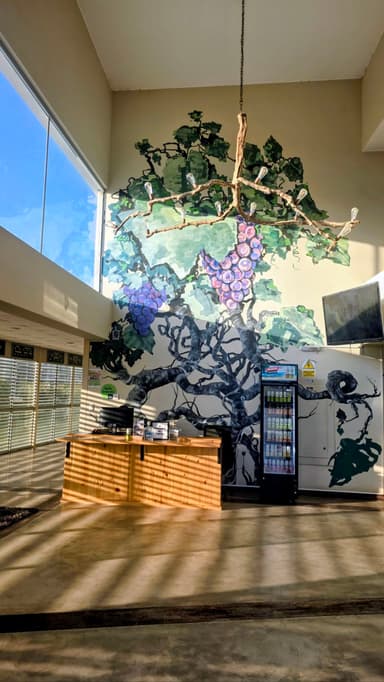 Un intérieur lumineux avec un mur peint de vignes.