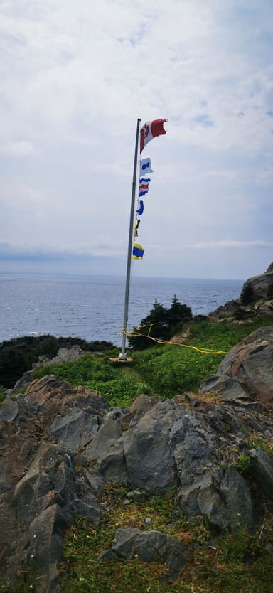 Un drapeau et des fanions flottent au-dessus de l'océan à Terre-Neuve-et-Labrador.