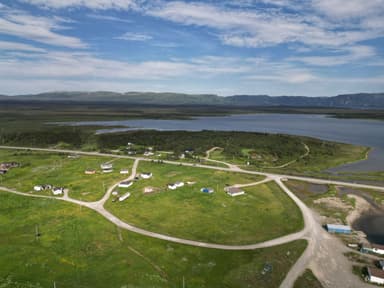 Une vue panoramique d'un paysage verdoyant avec des maisons et un lac.