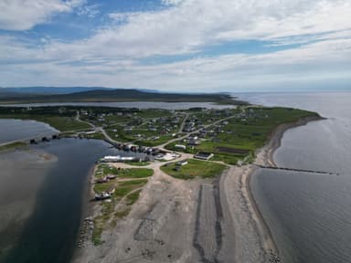 Une vue aérienne d'un paysage côtier avec des maisons et des routes.