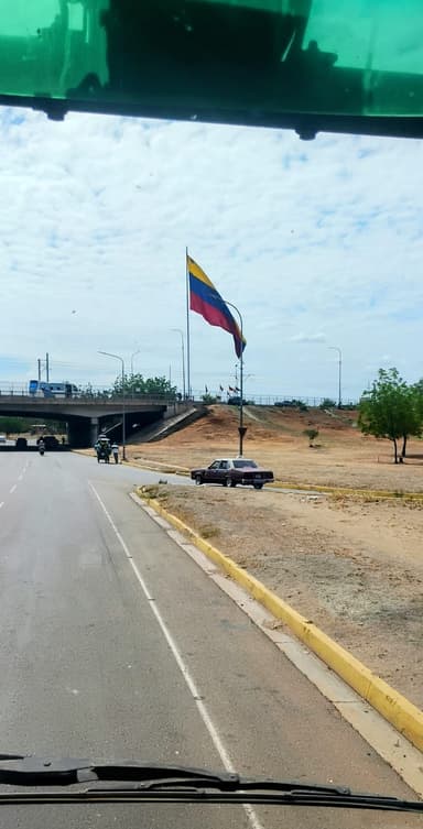 Un drapeau vénézuélien flottant près d'une route.