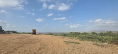Un véhicule sur une route près d'une rivière sous un ciel bleu.