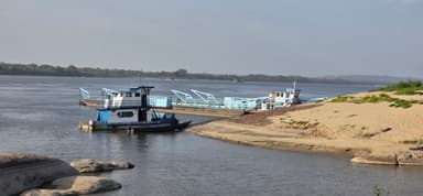 Un bateau sur le fleuve avec des rives sablonneuses.