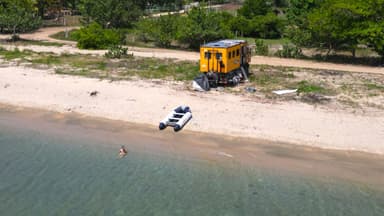 Une plage avec un bateau et une cabane jaune.