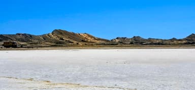 Un paysage désertique avec des montagnes sous un ciel bleu.