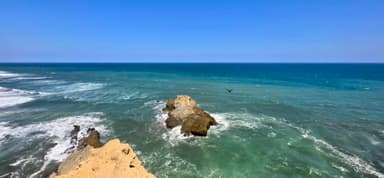 Une vue panoramique de la mer avec des rochers au premier plan.