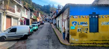 Une rue colorée avec des maisons et des voitures à Merida.
