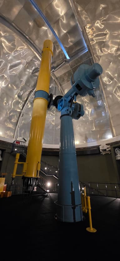 Un télescope coloré à l'intérieur d'un observatoire.