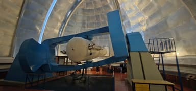 Un télescope dans un observatoire avec une lumière douce.