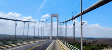 A bridge with a clear blue sky and distant hills in the background.