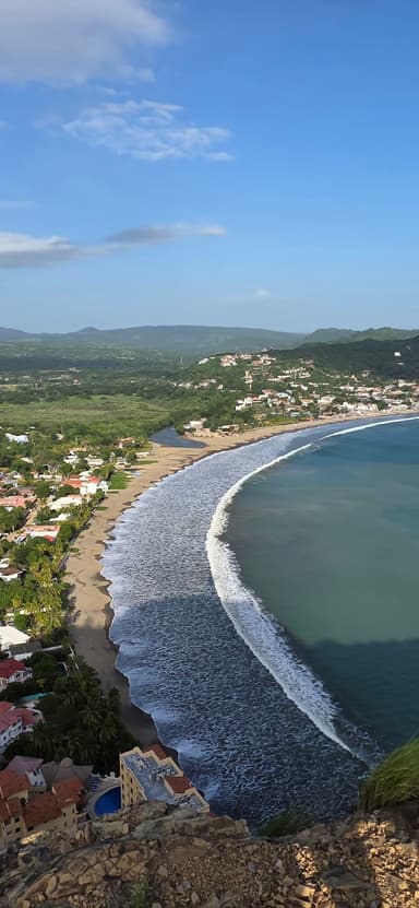 Une vue panoramique de la plage et des collines à Rivas, Nicaragua, sous un ciel bleu.