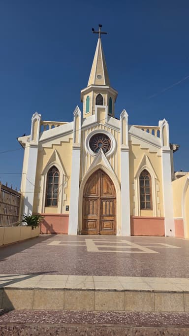 Une église avec une façade jaune sous un ciel bleu.