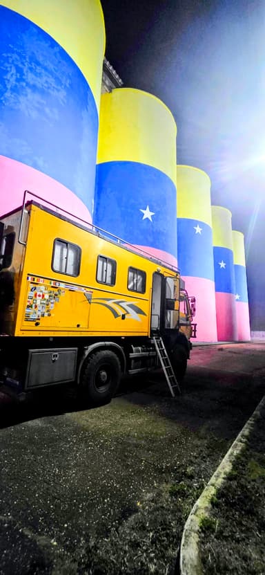 Un camion jaune devant des silos colorés à El Tigre.