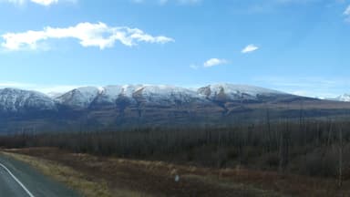 Des montagnes enneigées sous un ciel bleu à Whitehorse.
