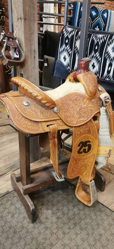 Une selle en cuir sur un support en bois dans un magasin.